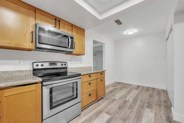 a kitchen with stainless steel appliances granite countertop a stove microwave and sink
