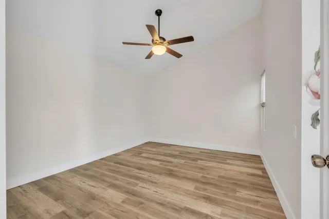 a view of empty room with wooden floor