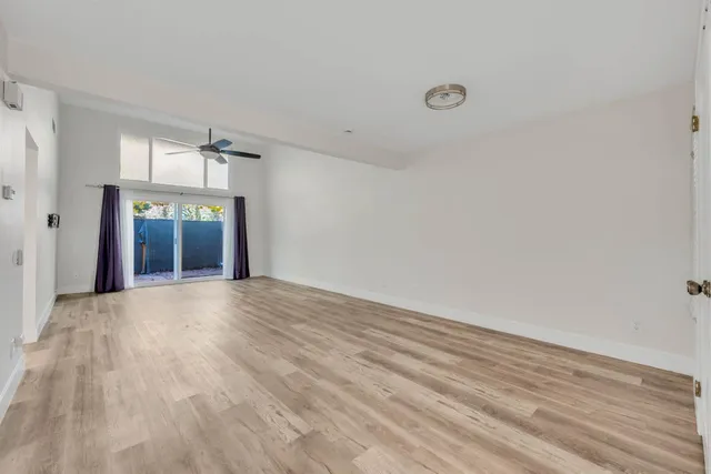 a view of an empty room with wooden floor and closet