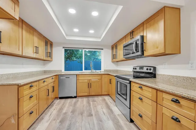a kitchen with granite countertop cabinets stainless steel appliances and a sink