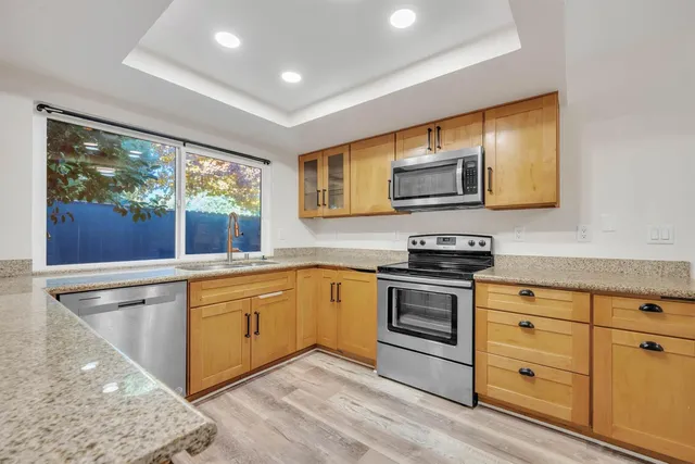 a kitchen with stainless steel appliances granite countertop a stove and a sink