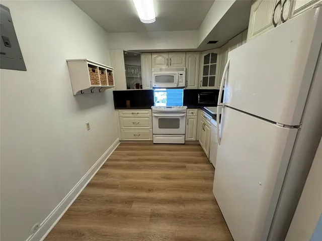 a kitchen with white cabinets and white appliances