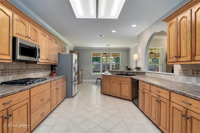an open kitchen with granite countertop a sink dishwasher stove top oven and wooden cabinets