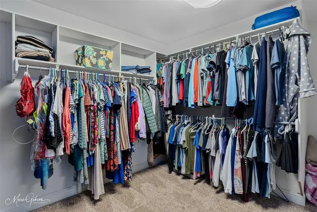 a view of walk in closet with clothes