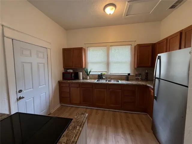 a kitchen with granite countertop a refrigerator and a sink