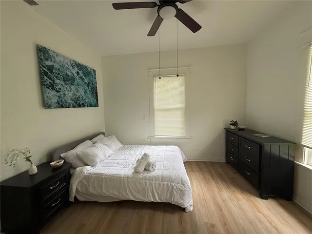 a bedroom with a bed and wooden floor