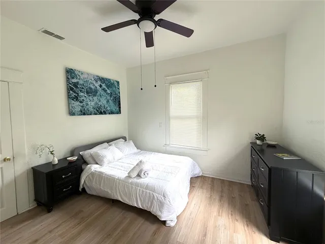 a bedroom with a bed and wooden floor