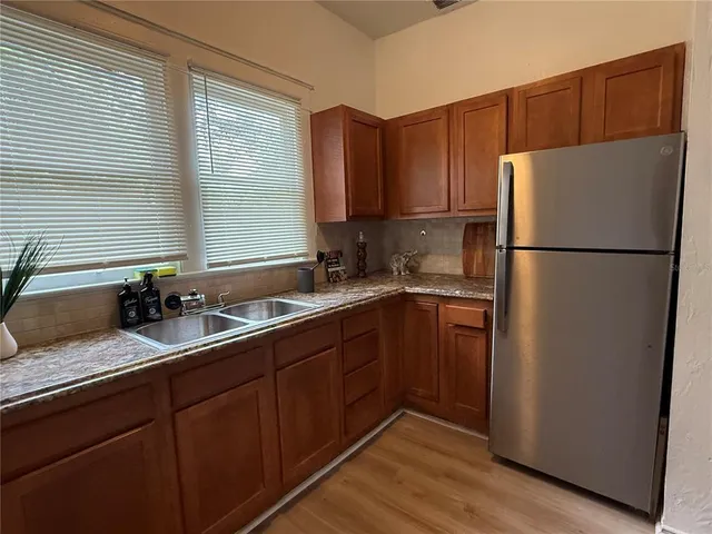 a kitchen with a refrigerator sink and cabinets