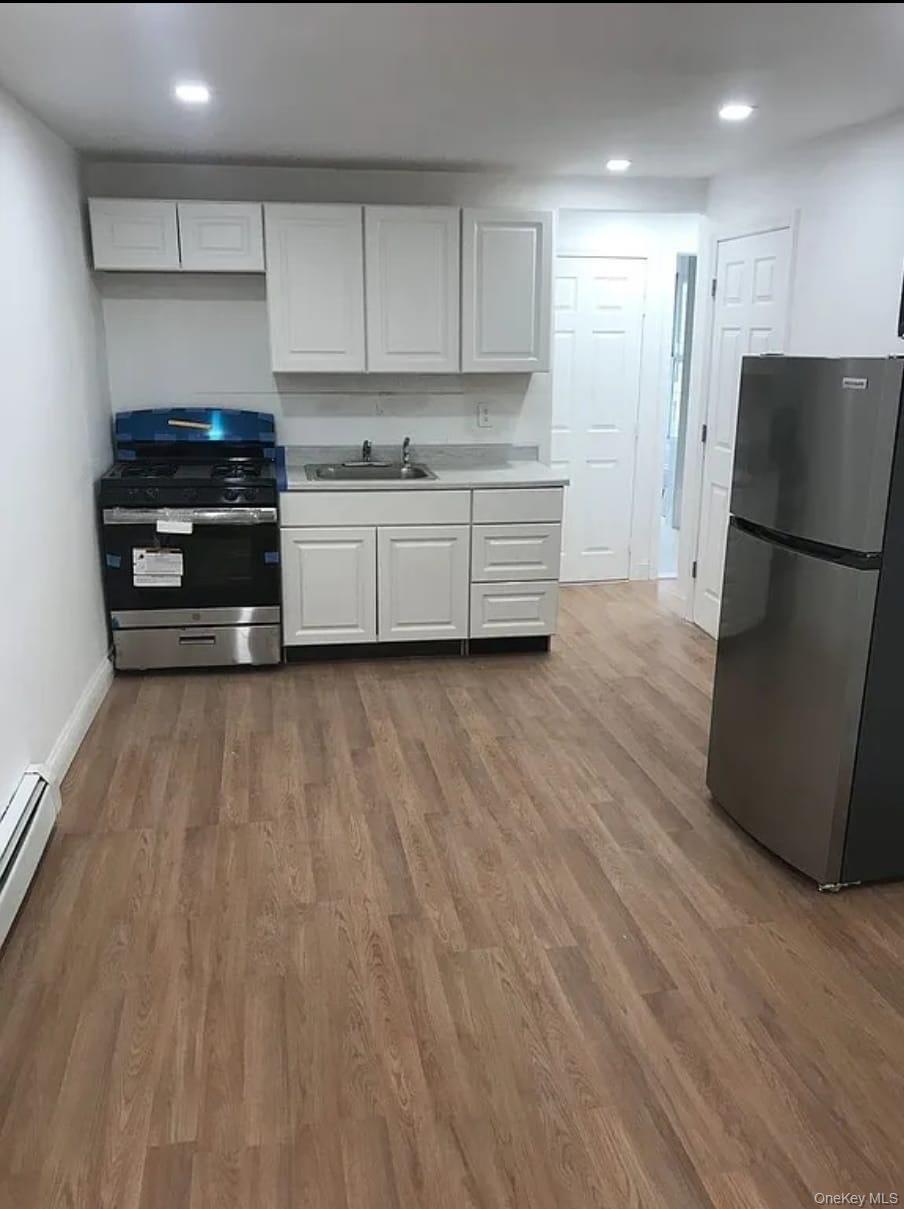 1094 Bushwick Avenue Brooklyn, NY 11221 - Photo 5 of 9 a kitchen with a refrigerator and a stove top oven