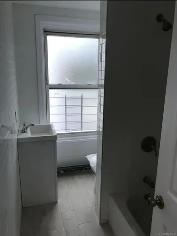 a bathroom with a bathtub and a window