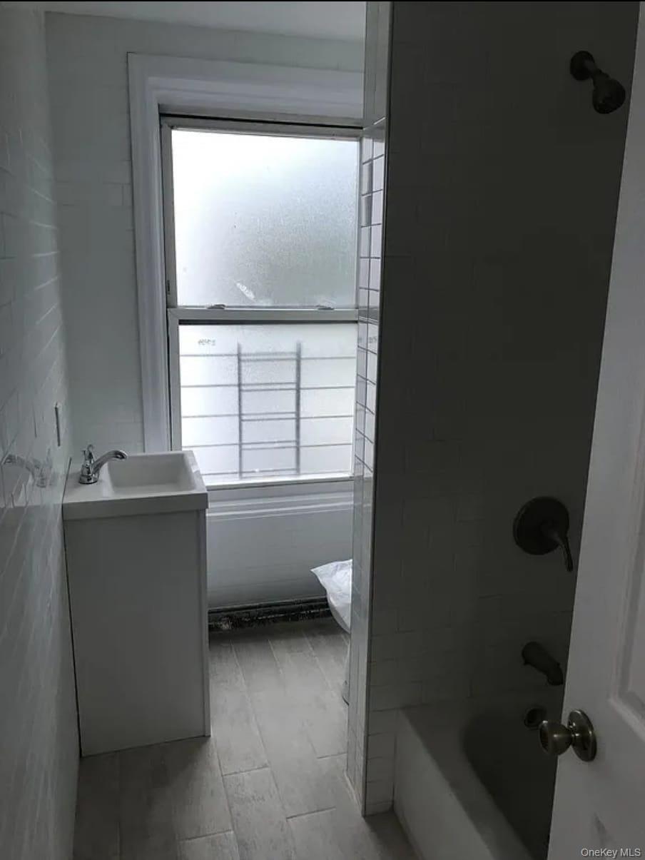 1094 Bushwick Avenue Brooklyn, NY 11221 - Photo 8 of 9 a bathroom with a bathtub and a window