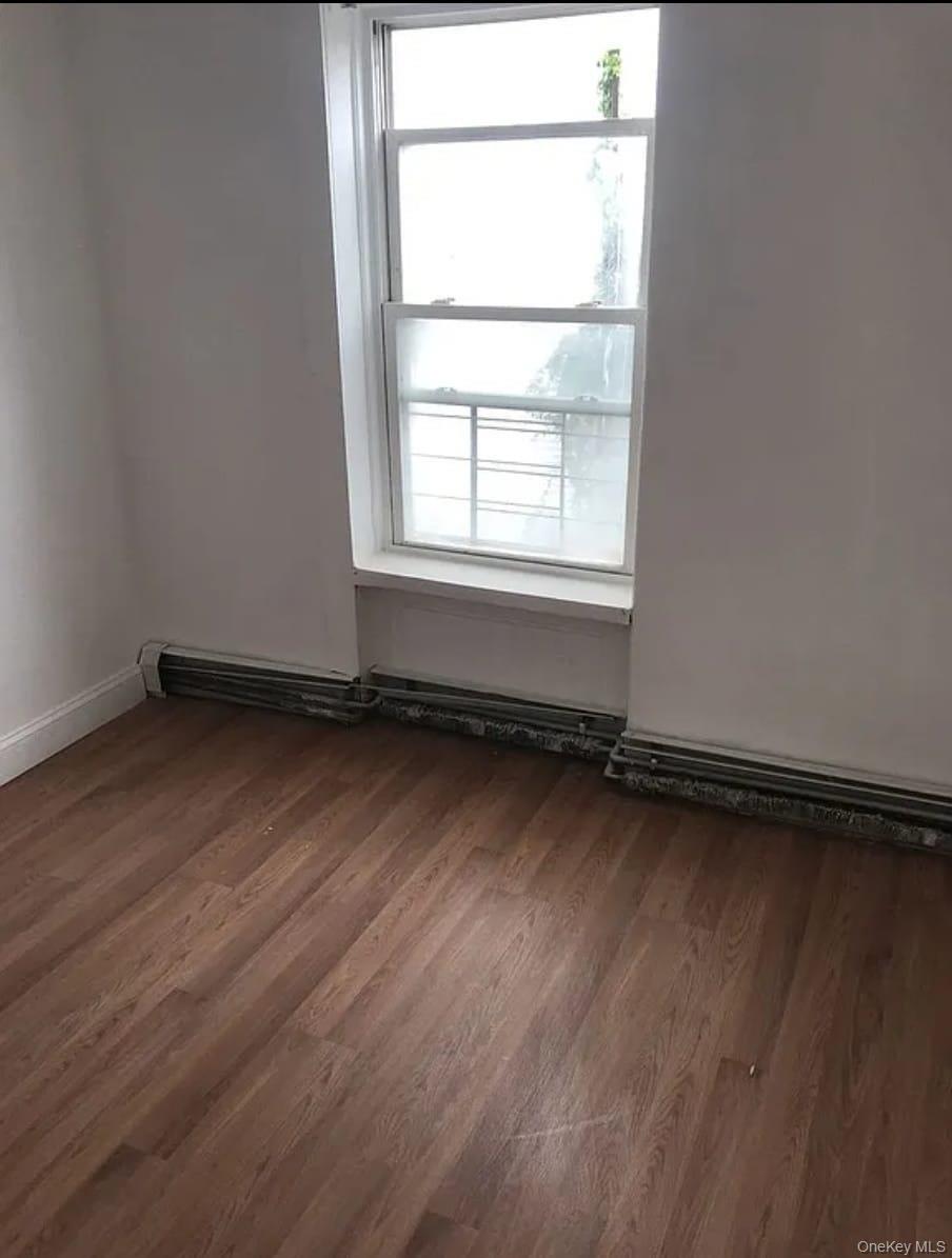 1094 Bushwick Avenue Brooklyn, NY 11221 - Photo 9 of 9 an empty room with wooden floor and windows