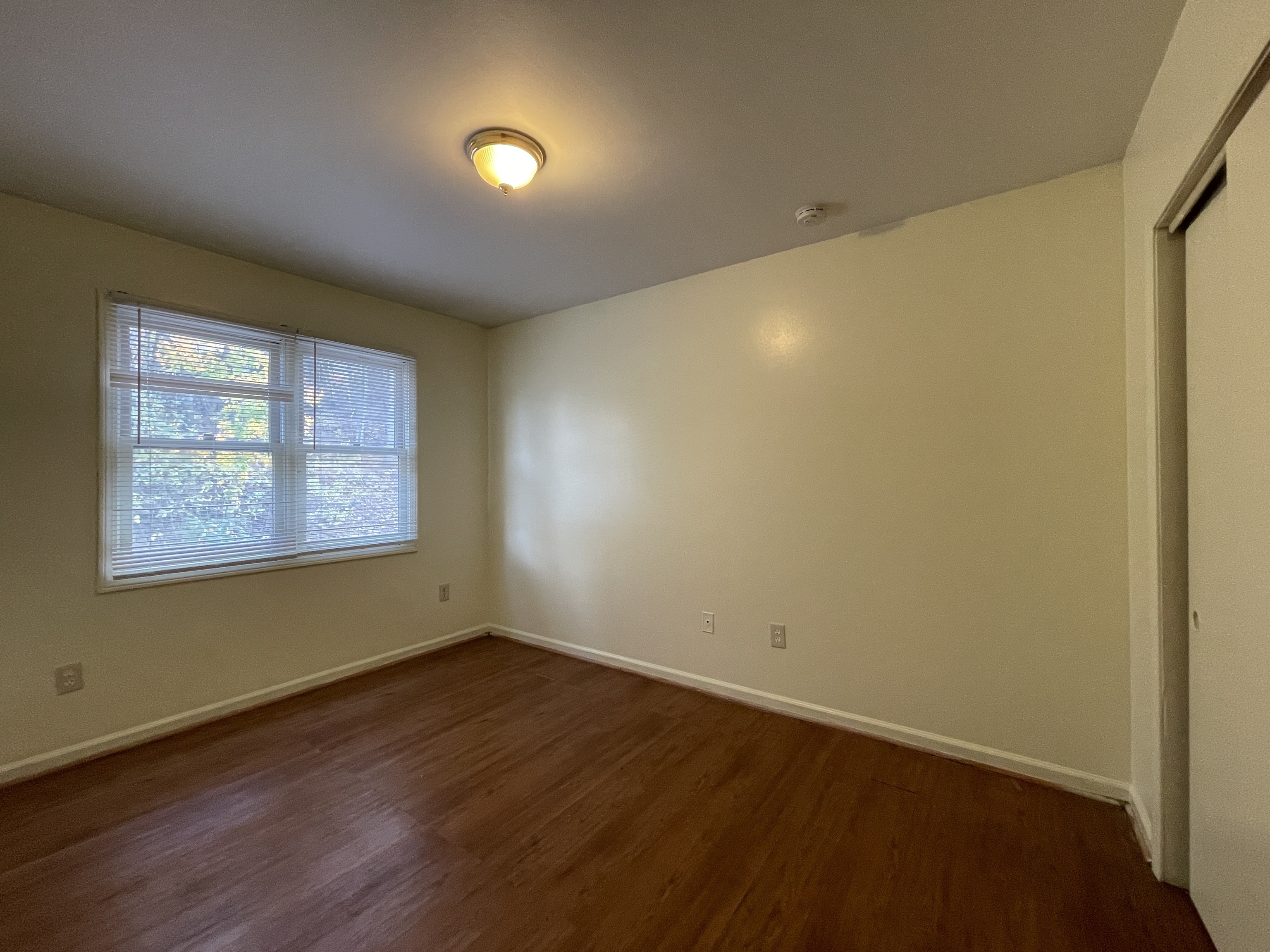 649 Newhall Street, Unit 3 Hamden, CT 06517 - Photo 7 of 9 a view of an empty room with wooden floor and a window