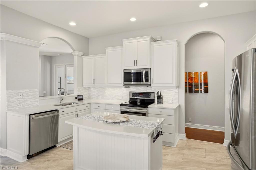 20441 Rookery Drive Estero, FL 33928 - Photo 14 of 41 a kitchen with stainless steel appliances a stove refrigerator sink and microwave