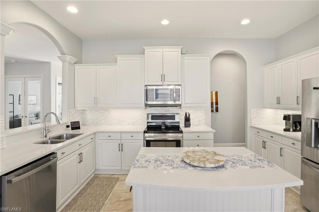 20441 Rookery Drive Estero, FL 33928 - Photo 15 of 41 a kitchen with stainless steel appliances kitchen island granite countertop a sink and cabinets
