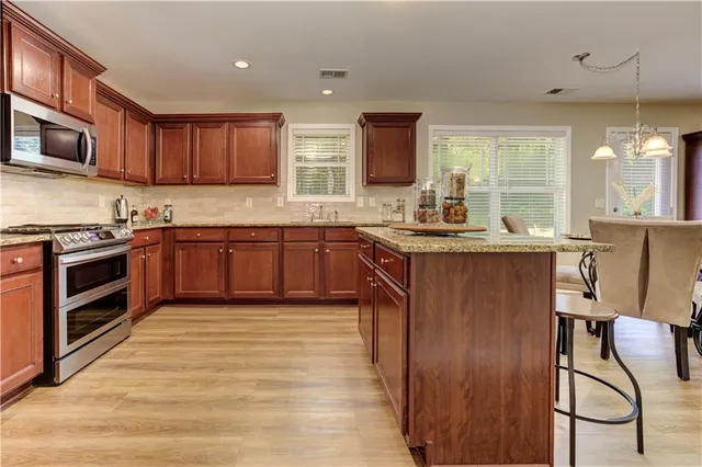 a kitchen with granite countertop wooden cabinets and stainless steel appliances