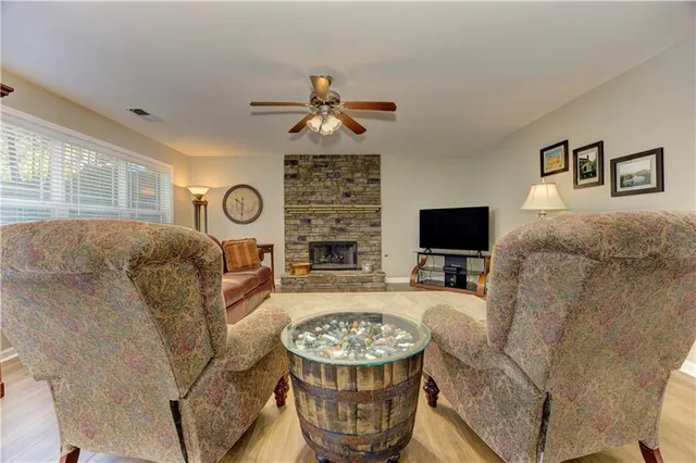 a living room with furniture a flat screen tv and a chandelier