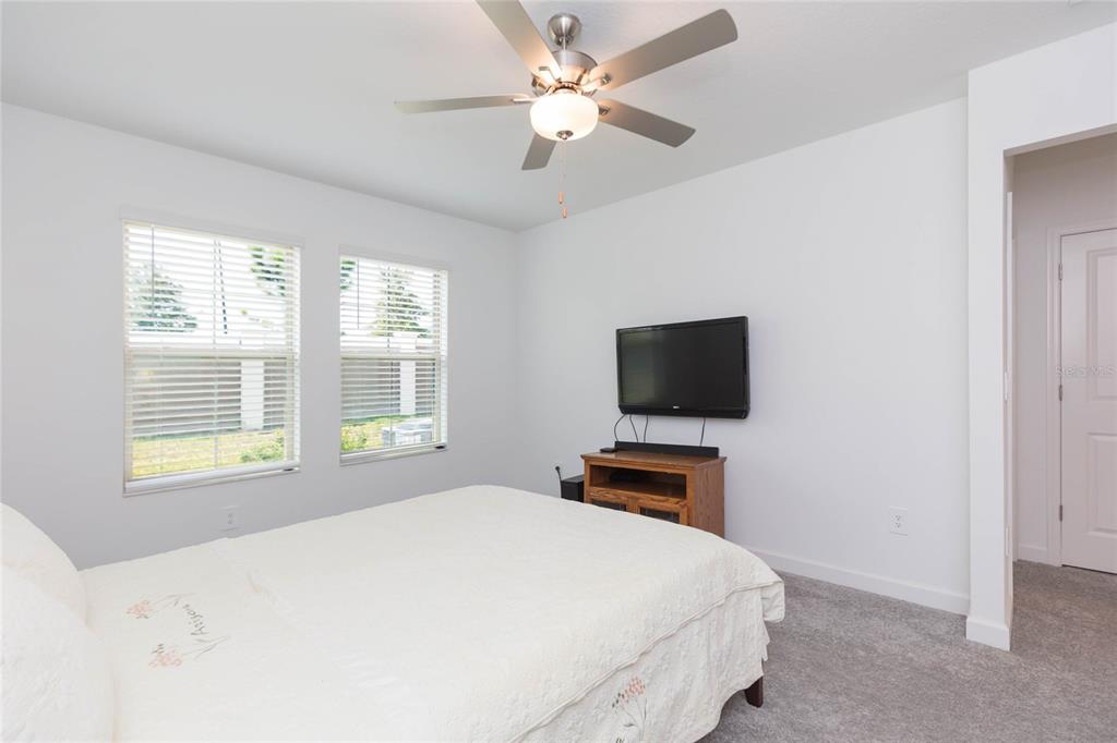 10806 Gable Dig Loop San Antonio, FL 33576 - Photo 24 of 73 a bedroom with a bed and a flat screen tv