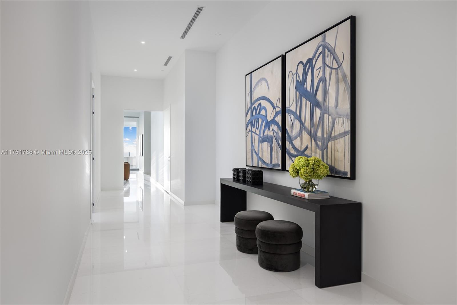 300 Biscayne Blvd Way, Unit PH5701 Miami, FL 33131 - Photo 7 of 21 a hallway with a table and a painting on the wall