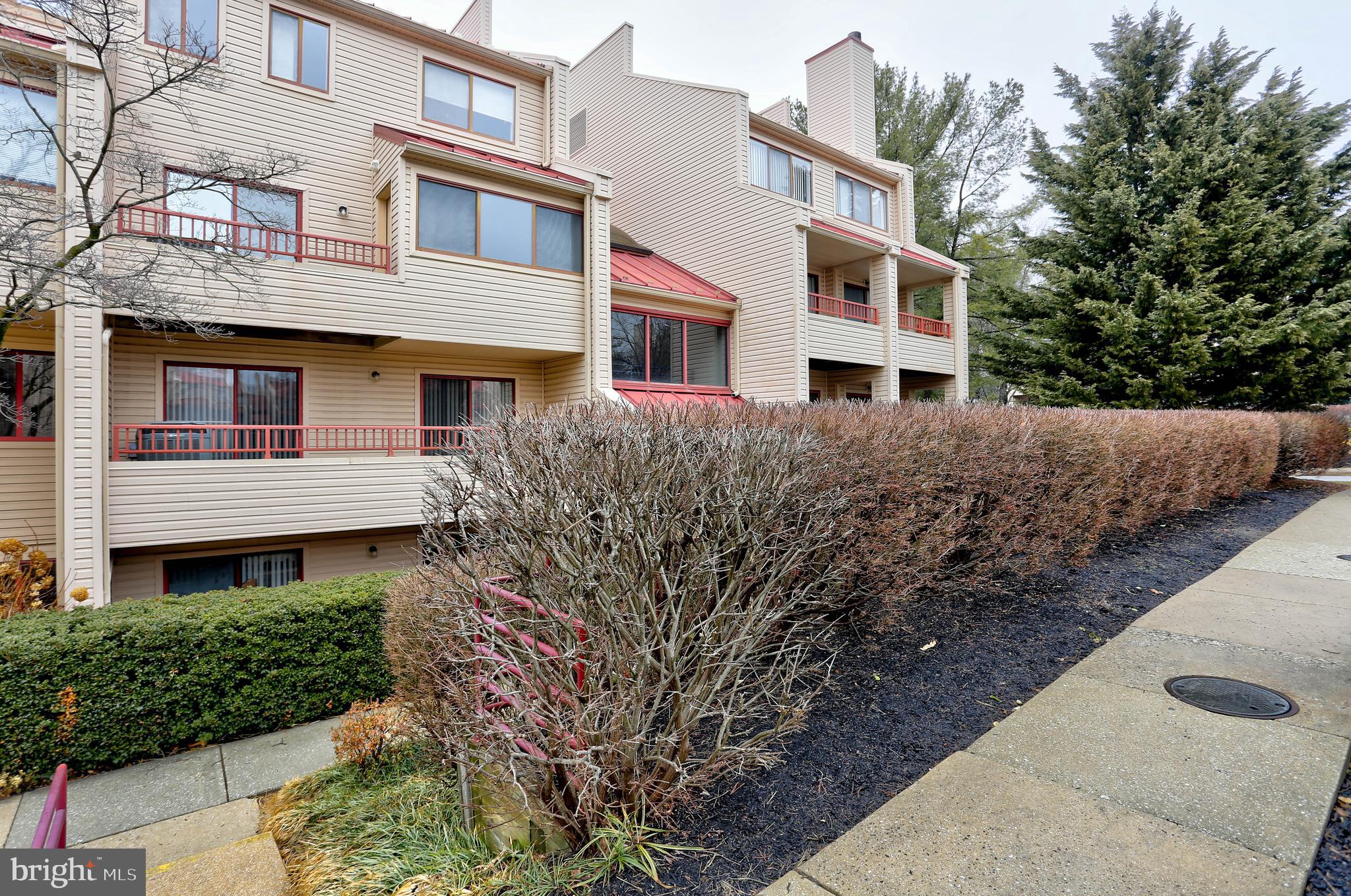8018 Valley Manor Road, Unit 1A Owings Mills, MD 21117 - Photo 22 of 24 a front view of a building with a garden