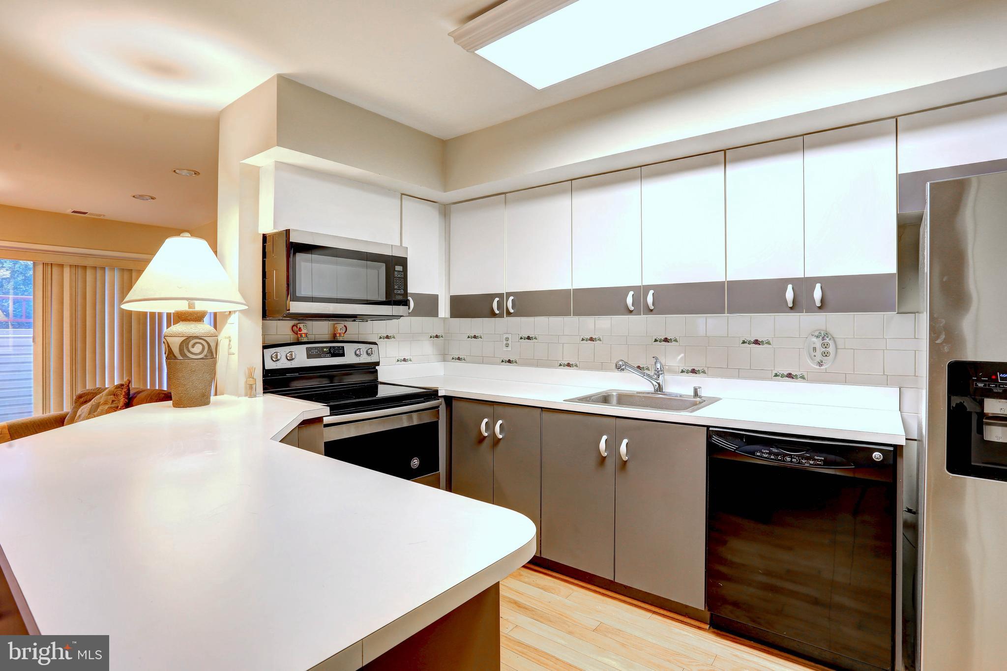 8018 Valley Manor Road, Unit 1A Owings Mills, MD 21117 - Photo 4 of 24 a kitchen with a sink a stove and cabinets