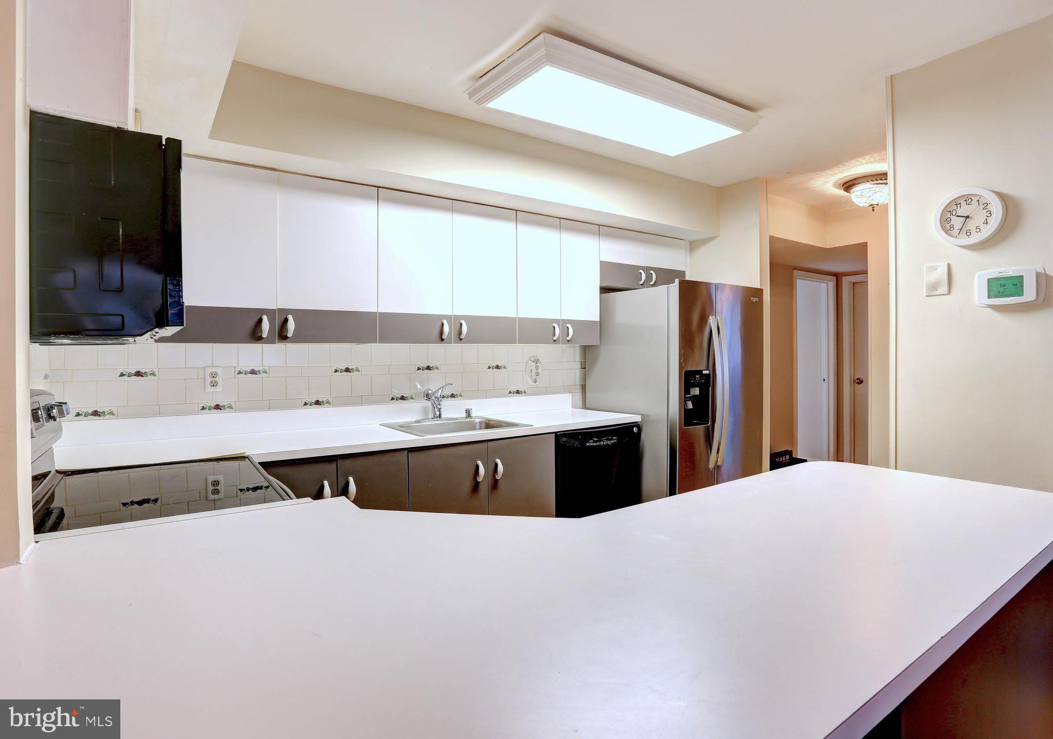 8018 Valley Manor Road, Unit 1A Owings Mills, MD 21117 - Photo 5 of 24 a large kitchen with a stove a sink and a refrigerator