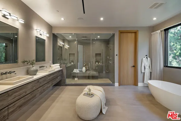 a spacious bathroom with a large tub shower and sink
