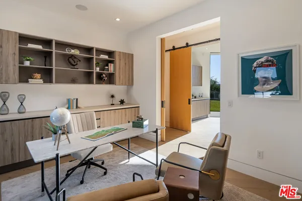 a work room with furniture and view of kitchen