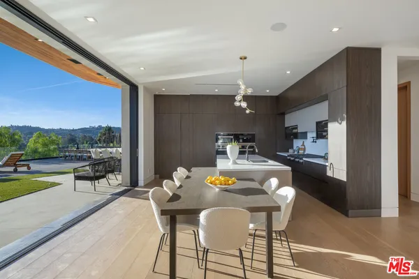 a dining room with furniture and a floor to ceiling window