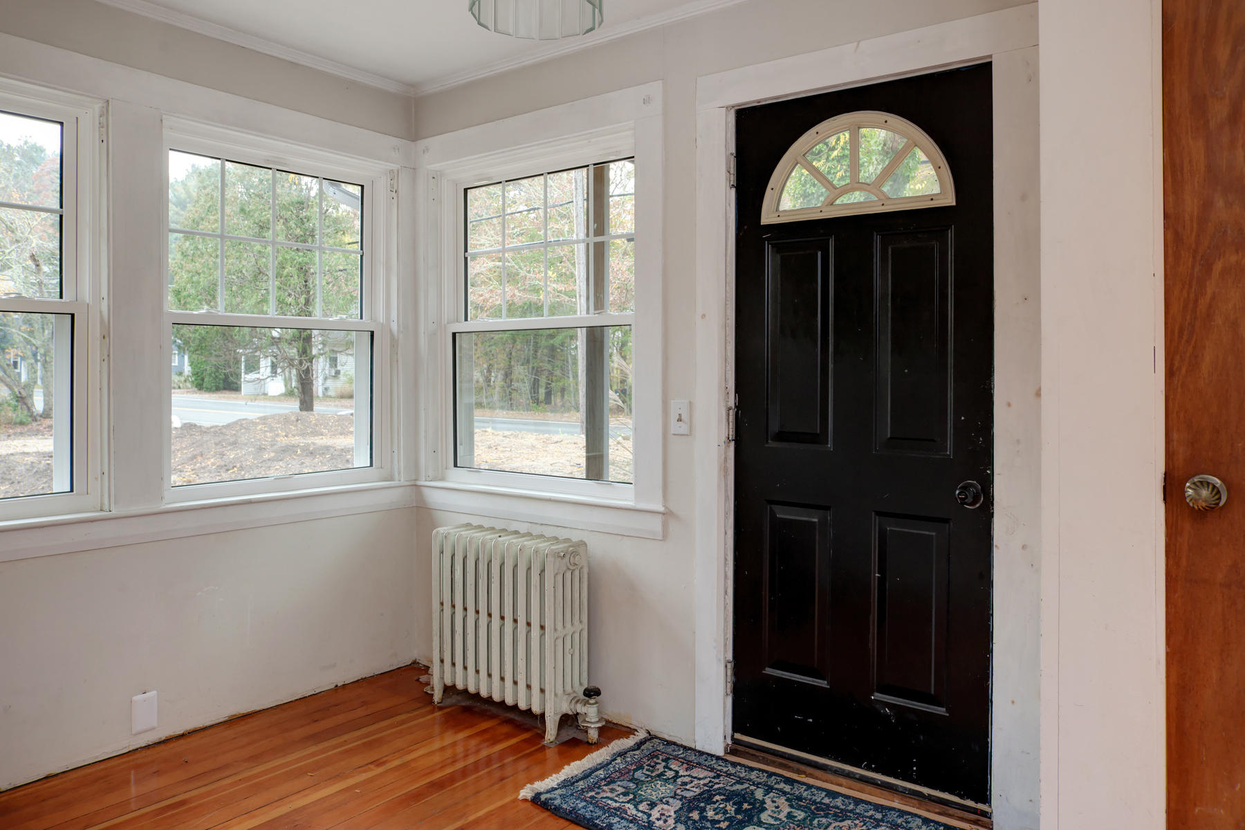 27 County Road Monument Beach, MA 02532 - Photo 2 of 17 an empty room with wooden floor closet and windows