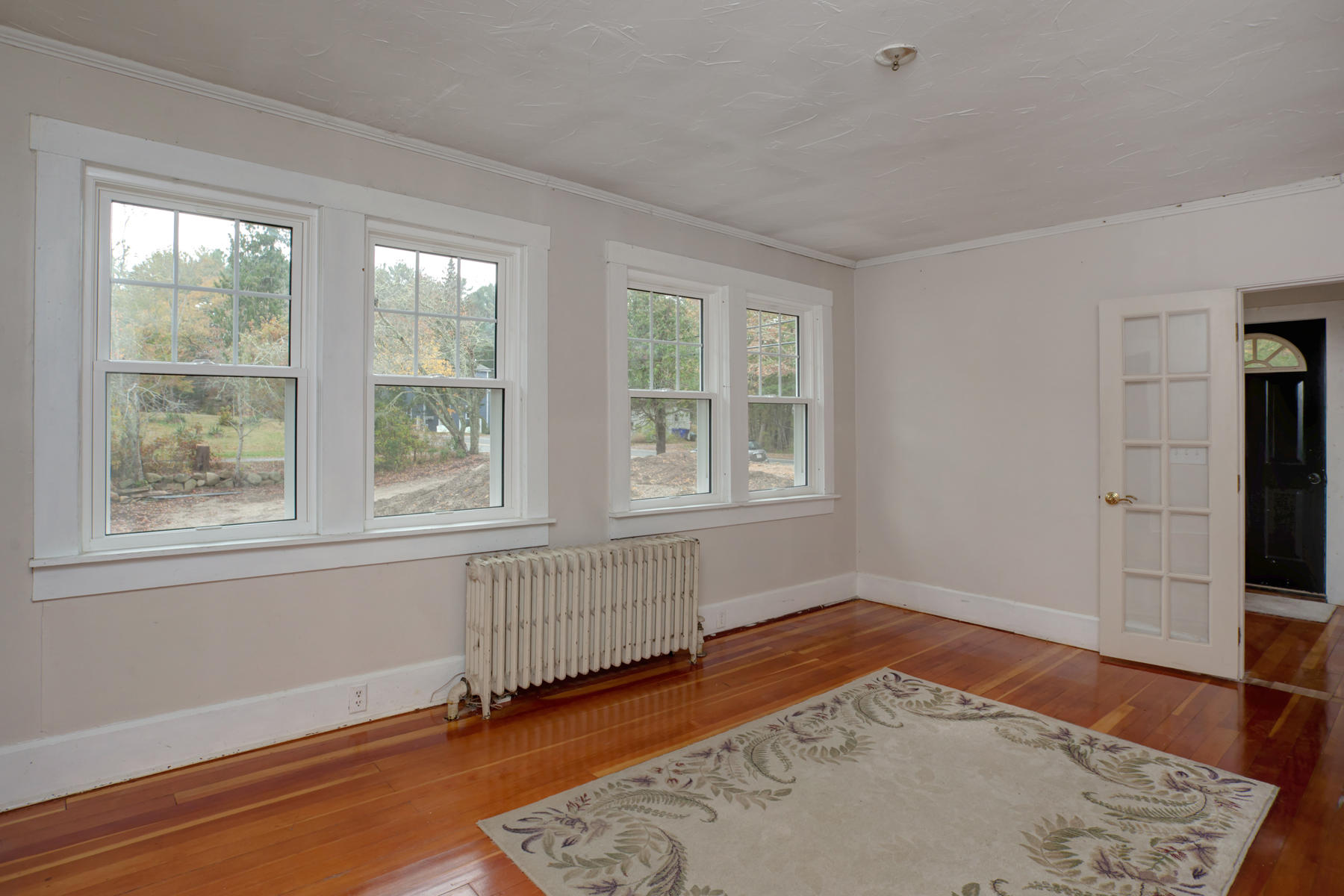 27 County Road Monument Beach, MA 02532 - Photo 3 of 17 an empty room with wooden floor and windows