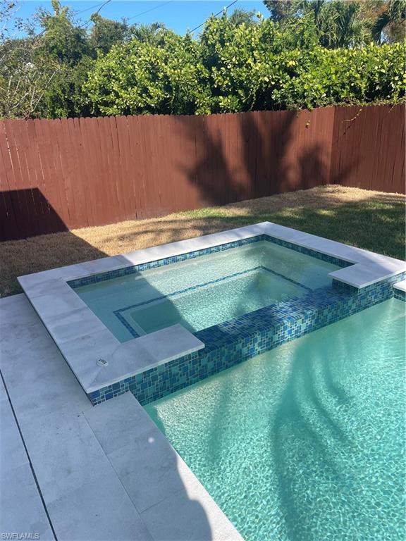 1175 9th Avenue North Naples, FL 34102 - Photo 27 of 33 View of swimming pool with a fenced backyard and a pool with connected hot tub