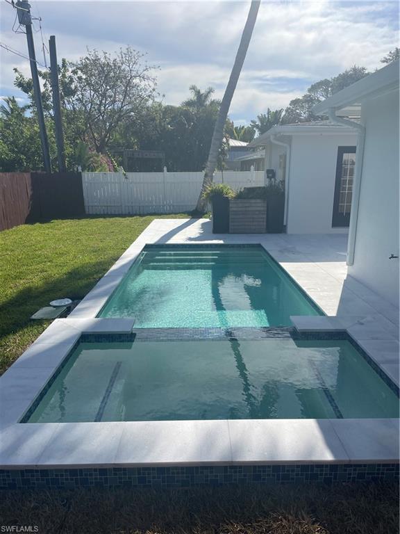 1175 9th Avenue North Naples, FL 34102 - Photo 28 of 33 View of pool featuring a yard, a pool with connected hot tub, a fenced backyard, and a patio area