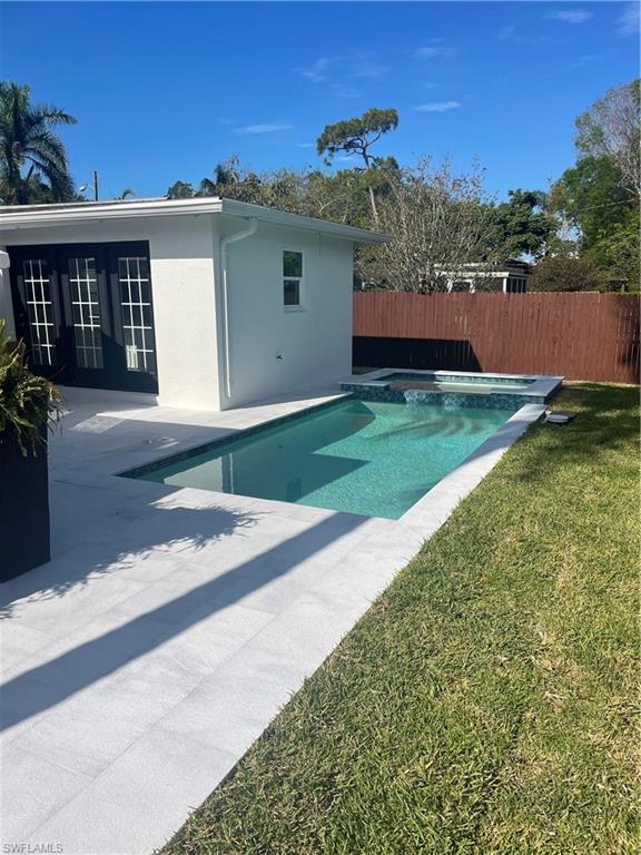 1175 9th Avenue North Naples, FL 34102 - Photo 32 of 33 View of swimming pool featuring a jacuzzi, a patio area, french doors, and fence