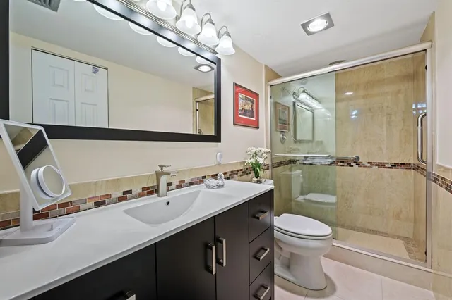 a bathroom with a sink a toilet and shower