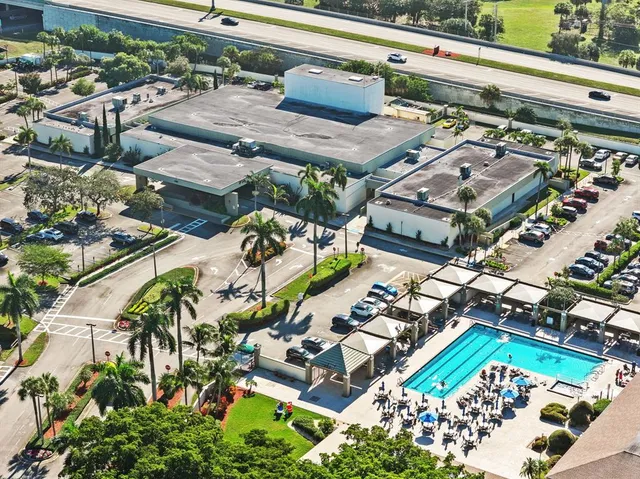 an aerial view of a resort with swimming pool and outdoor seating