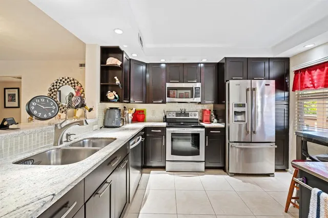 a kitchen with kitchen island a refrigerator sink and wooden cabinets