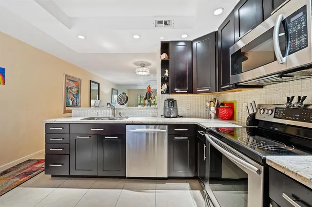 a kitchen with stainless steel appliances granite countertop a sink and cabinets