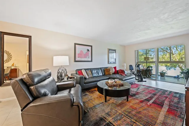a living room with furniture a rug and a large window
