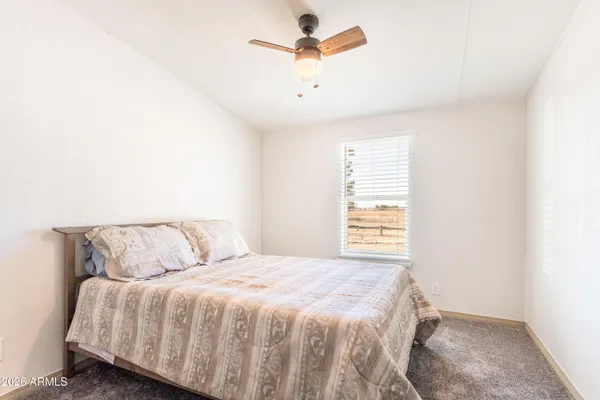 a bedroom with a bed and a ceiling fan