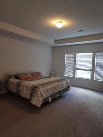 a spacious bedroom with a bed and a large window