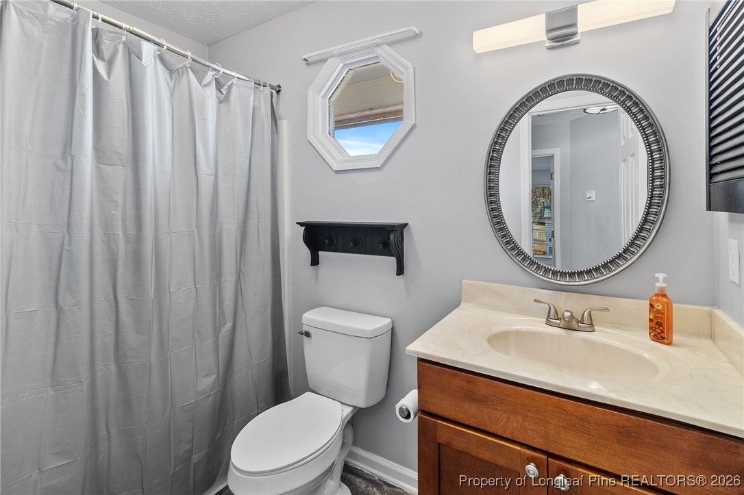 921 Flintwood Road Fayetteville, NC 28314 - Photo 33 of 44 a bathroom with a sink mirror vanity and toilet