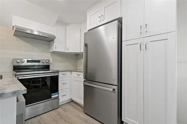 a kitchen with stainless steel appliances a refrigerator and a stove top oven
