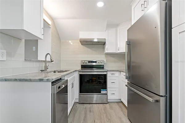 a kitchen with a sink stove and refrigerator