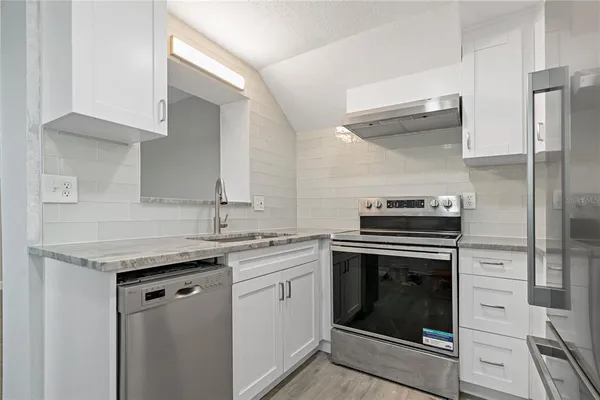 a kitchen with a stove sink and refrigerator