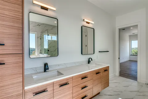 a bathroom with double vanity sink and a mirror