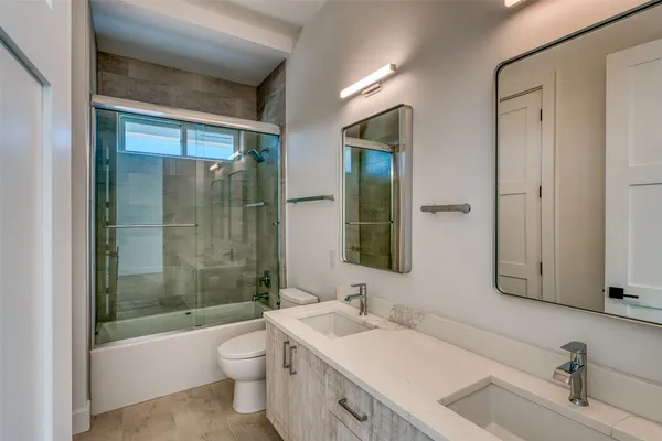 an empty room with wooden floor closet and windows