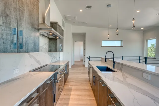 a large kitchen with stainless steel appliances lots of counter space and a sink