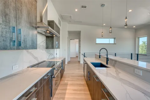 a large kitchen with stainless steel appliances lots of counter space and a sink