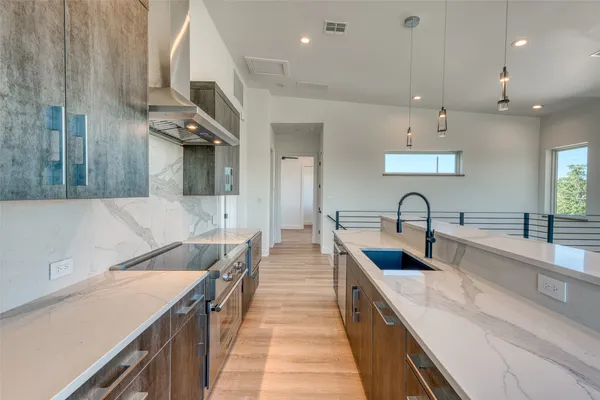 a large kitchen with stainless steel appliances lots of counter space and a sink